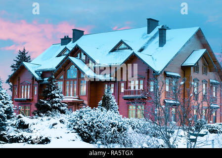 luxurious log house, wooden mansion covered by snow in winter park