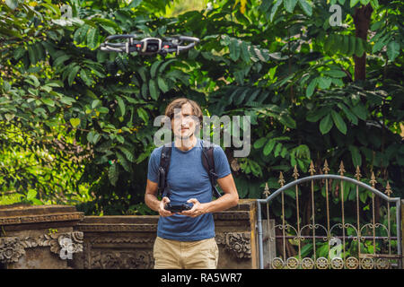 Young man launches a drone into the sky. The island of Bali Stock Photo