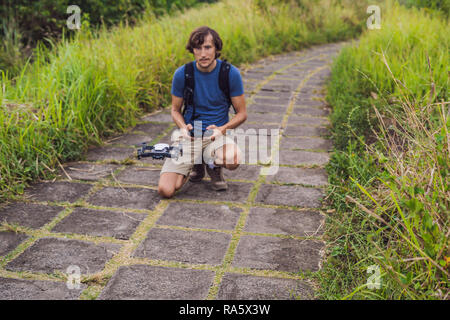 Young man launches a drone into the sky. The island of Bali Stock Photo