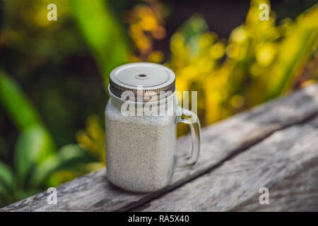 Healthy layered dessert with chia pudding in a mason jar on rustic background Stock Photo