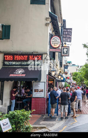 Singapore - 14th December 2018: People drinking in pubs on Boat Quay. The street is popular with both tourists and expats. Stock Photo