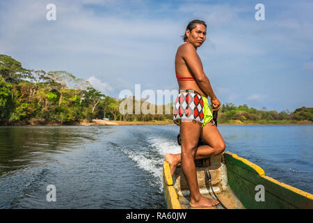 Embera Drua Villiage, Panama - Mar 3rd 2018 - An indigenous man dressing with his traditional clothes while driving a wood boat at Embera Drua Villiag Stock Photo