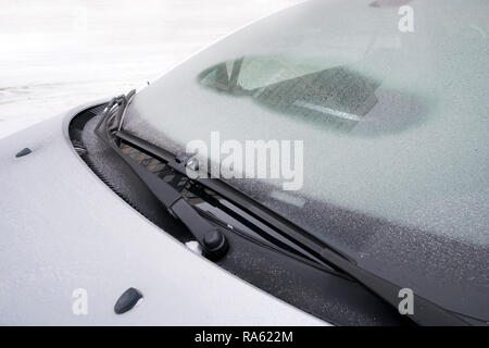 Windscreen wipers cleaning a windshield of a car from the snow. defrost, defroster in the cold Stock Photo
