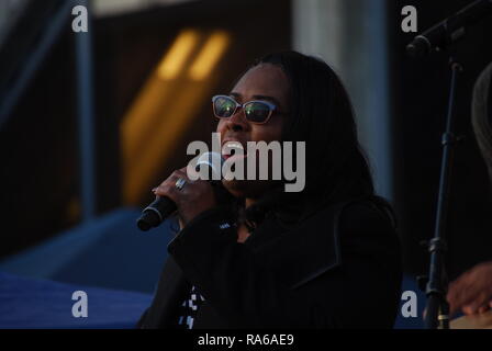 Oakland, California, USA. 1st Jan, 2019. Oscar Grant's mother, Wanda Johnson, sings at a vigil outside the Fruitvale BART station in Oakland, California, marking the tenth anniversary since he was shot and killed by a police officer. Credit: Scott Morris/Alamy Live News Stock Photo