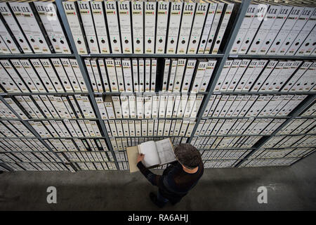 Bad Arolsen, Germany. 11th Dec, 2018. Christian Groh, Head of the Archive Department, leafs through a file at a filing cabinet in the provisional archive of the International Tracing Service (ITS). The ITS is an archive and documentation centre on Nazi persecution and the liberated survivors. (to dpa 'International Tracing Service ITS' from 02.01.2019) Credit: Swen Pförtner/dpa/Alamy Live News