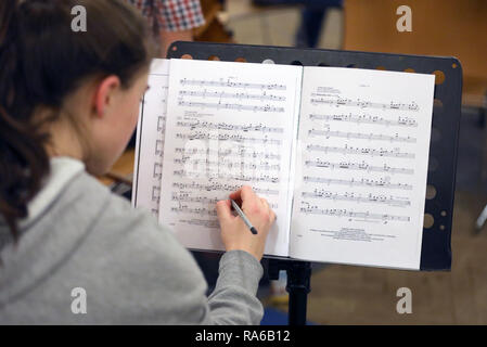 Schwerin, Germany. 19th Dec, 2018. A young musician in the Schwerin Youth Symphony Orchestra writes on her sheet of music at the chaos rehearsal, the orchestra's very first rehearsal. The orchestra with over 60 girls and boys aged between 12 and 19 plays pieces for a new programme for the first time. According to estimates, more than 150,000 kids play in about 5000 children's and youth orchestras in Germany. They range from simple playing circles to full symphony orchestras. Credit: Bernd Wüstneck/dpa/Alamy Live News Stock Photo