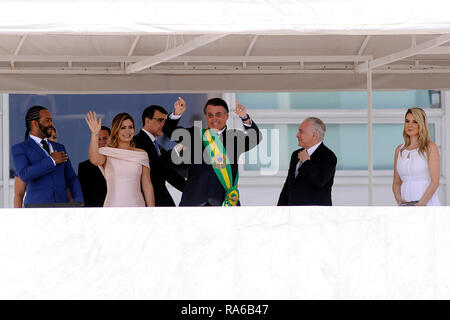 Brasilia, Brazil. 01st Jan, 2019. Brazil's new president Jair Bolsonaro (M) waves to the crowd from the Planalto presidential palace. Next to him are his wife Michelle Bolsonaro (front, 2nd from left) and the outgoing Brazilian President Michel Temer (2nd from right). The ultra-right ex-military Jair Bolsonaro has been sworn in as the new president of Brazil. The 63-year-old took his oath of office in Congress on Tuesday. Credit: Alan Morici/dpa/Alamy Live News Stock Photo
