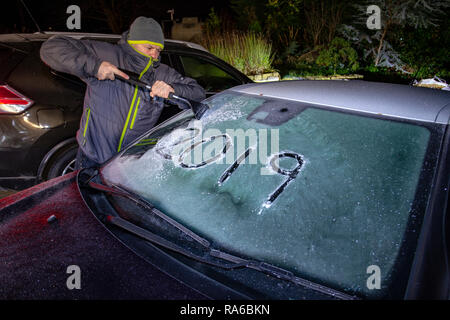 Lixwm, North Wales UK. 2nd Jan, 2019. UK Weather: A severe drop in temperatures overnight and the first frost of 2019 as a motoroist begins to clear a windscreen of overnight frost in the village of Lixwm, Wales Credit: DGDImages/Alamy Live News Stock Photo