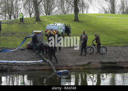 Basildon, Essex, UK. 2nd Jan 2019. Essex Police officers along with the Environmental Agency drain the fishing lake in Gloucester Park Basildon Essex in the search for a missing 28 year old man. Jack Morrad was last seen at 2:30am on CCTV on Sunday December 23 in nearby Blake Avenue. Throughout the festive period Police officers and Jack's family and friends have carried out searches of the park and surrounding waterways. Following the conclusion of these searches it was decided to completely drain the main fishing lake. Credit: MARTIN DALTON/Alamy Live News Stock Photo