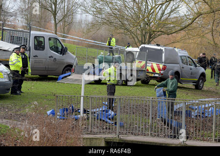 Basildon, Essex, UK. 2nd Jan 2019. Essex Police officers along with the Environmental Agency drain the fishing lake in Gloucester Park Basildon Essex in the search for a missing 28 year old man. Jack Morrad was last seen at 2:30am on CCTV on Sunday December 23 in nearby Blake Avenue. Throughout the festive period Police officers and Jack's family and friends have carried out searches of the park and surrounding waterways. Following the conclusion of these searches it was decided to completely drain the main fishing lake. Credit: MARTIN DALTON/Alamy Live News Stock Photo