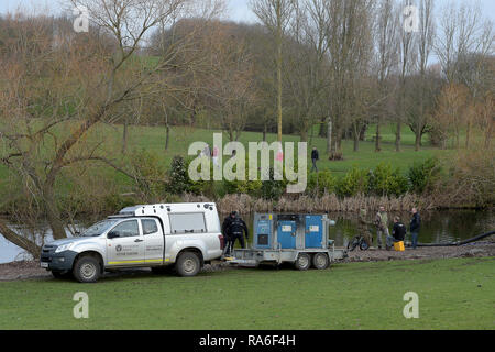 Basildon, Essex, UK. 2nd Jan 2019. Essex Police officers along with the Environmental Agency drain the fishing lake in Gloucester Park Basildon Essex in the search for a missing 28 year old man. Jack Morrad was last seen at 2:30am on CCTV on Sunday December 23 in nearby Blake Avenue. Throughout the festive period Police officers and Jack's family and friends have carried out searches of the park and surrounding waterways. Following the conclusion of these searches it was decided to completely drain the main fishing lake. Credit: MARTIN DALTON/Alamy Live News Stock Photo