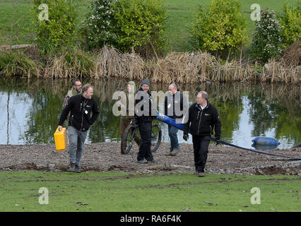 Basildon, Essex, UK. 2nd Jan 2019. Essex Police officers along with the Environmental Agency drain the fishing lake in Gloucester Park Basildon Essex in the search for a missing 28 year old man. Jack Morrad was last seen at 2:30am on CCTV on Sunday December 23 in nearby Blake Avenue. Throughout the festive period Police officers and Jack's family and friends have carried out searches of the park and surrounding waterways. Following the conclusion of these searches it was decided to completely drain the main fishing lake. Credit: MARTIN DALTON/Alamy Live News Stock Photo