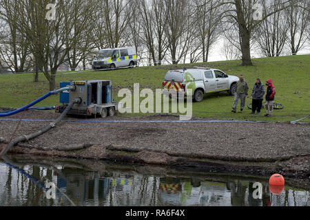 Basildon, Essex, UK. 2nd Jan 2019. Essex Police officers along with the Environmental Agency drain the fishing lake in Gloucester Park Basildon Essex in the search for a missing 28 year old man. Jack Morrad was last seen at 2:30am on CCTV on Sunday December 23 in nearby Blake Avenue. Throughout the festive period Police officers and Jack's family and friends have carried out searches of the park and surrounding waterways. Following the conclusion of these searches it was decided to completely drain the main fishing lake. Credit: MARTIN DALTON/Alamy Live News Stock Photo