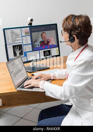 Symbol photo for telemedicine, doctor in a practice, communicates with the patient via a webcam, patient data and findings on Stock Photo