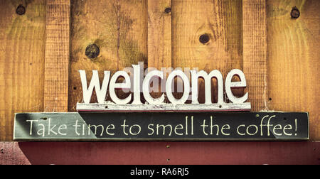 Welcome, Take time tu smell the coffee text sign on a wooden wall with copy space. Stock Photo