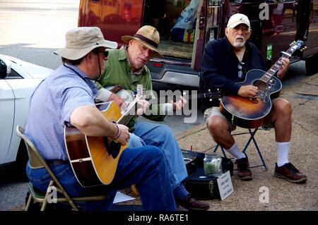 Saint Louis, MO--Sept 9, 2017; three bluegrass street musicians in hats playing guitars and a banjo outside the soulard farmers market for tips Stock Photo