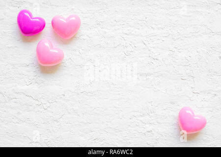 Valentine day background with pink hearts on grunge white wood background, top view with copy space. Flat lay minimal style image. Stock Photo