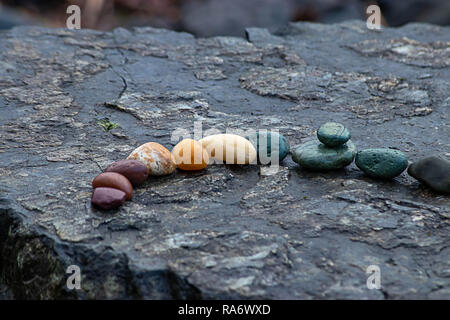 stone slab with small colorful stones resting on it Stock Photo