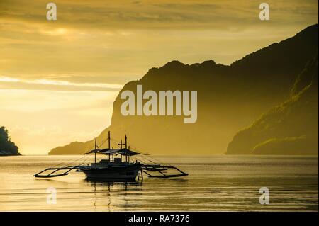 Silhouete of Outrigger at sunset in El Nido, Bacuit Archipelago, Palawan, Philippines Stock Photo