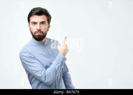 Stylish handsome young hispanic man pointing aside. Stock Photo