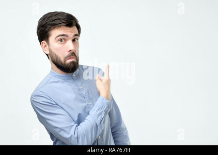Stylish handsome young hispanic man pointing aside. Stock Photo