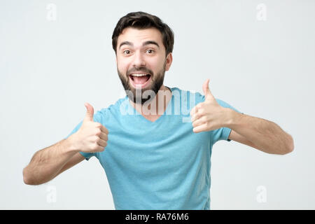Smiling man showing both thumbs up and looking at camera. Stock Photo