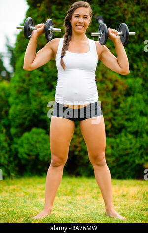 Pregnant Female Doing Shoulder Press Exercise With Dumbbells In  Stock Photo