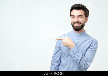 Stylish handsome young hispanic man pointing aside. Stock Photo