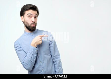 Stylish handsome young hispanic man pointing aside. Stock Photo
