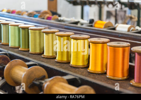Whitchurch Silk Mill in Hampshire, UK - close-up of colourful silk yarn on bobbins ready for spinning Stock Photo