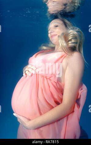 Pregnant woman, underwater fashion in a pool Stock Photo