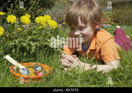 Boy found Easter eggs in Easter basket Stock Photo
