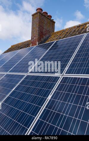 Solar panels fitted to the tiled roof of a home, United Kingdom, Europe Stock Photo