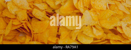 background corrugated golden chips with texture. A variety of potato chips background. Background corrugated golden chips with texture. Stock Photo