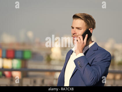 Manager with beard on smiling face hold phone. Business communication and digital marketing. modern life and new technology. Man in formal outfit with mobile phone. Businessman or ceo urban fashion. Stock Photo