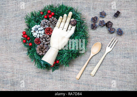 Christmas wreath with hand holding chocolate Stock Photo