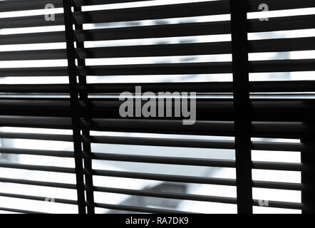 Opened venetian plastic blinds in black and white. Plastic window with blinds. Interior design of living room with window horizontal blinds. Window sl Stock Photo