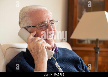 Smiling Senior Man Using Phone At Home Stock Photo