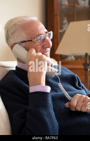 Smiling Senior Man Using Phone At Home Stock Photo