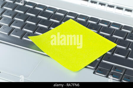 Empty yellow sticky paper note on laptop keyboard with copy space Stock Photo