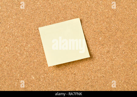 Empty yellow sticky paper memo note on cork board with copy space Stock Photo
