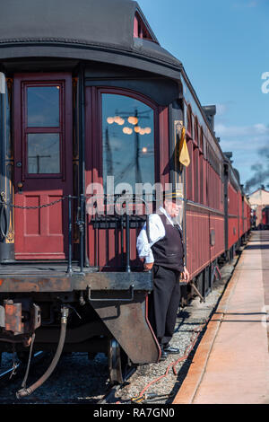 Strasburg, PA, USA - October 16, 2015: A conductor on the Strasburg Rail Road steam locomotive as it leaves at the train station. Stock Photo