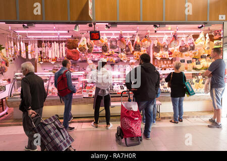 Customers wait their turn at n Italian butcher vendor inside the central market in Torino, Italy Stock Photo