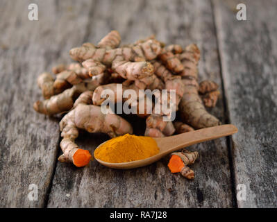fresh turmeric roots on wooden table Stock Photo