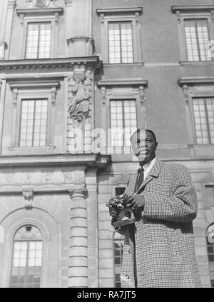 Nat King Cole. March 17, 1919 - Febryary 15, 1965. American jazz pianist and singer. Pictured here during a visit to Stockholm Sweden 1954 when performing there. He is sightseing in the Swedish capital and visits the Royal Castle, and snaps some pictures with his camera. Photo Kristoffersson. Stock Photo