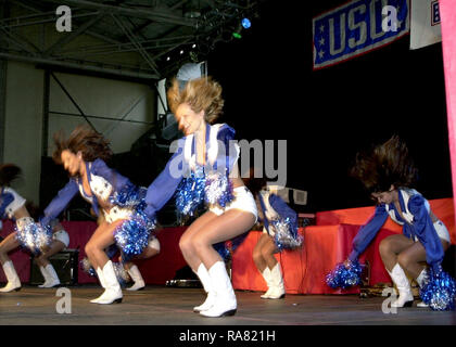 The Dallas Cowboys Cheerleaders perform during the Secretary of Defense Holiday Tour 2000, in Hangar 3 at Ramstein Air Base, Germany, on December 17th 2000. Stock Photo