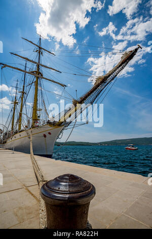 TIVAT, MONTENGRO - MAY 16, 2017: Vintage sailing frigate ship moored at a harbor with crystal clear blue waters of Adriatic Sea during sunny spring da Stock Photo