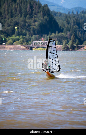 The surfer enjoying a walk with sail under the fresh wind along the Columbia River in the Hood River - the center of windsurfing as a professional spo Stock Photo