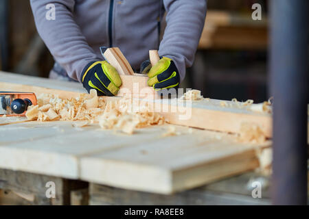 Woodworking - man using hand planer on a pine wood Stock Photo