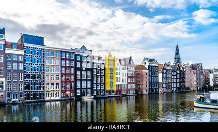 Historic Houses along the Damrak Canal in the heart of the historic city of Amsterdam in the Netherlands Stock Photo